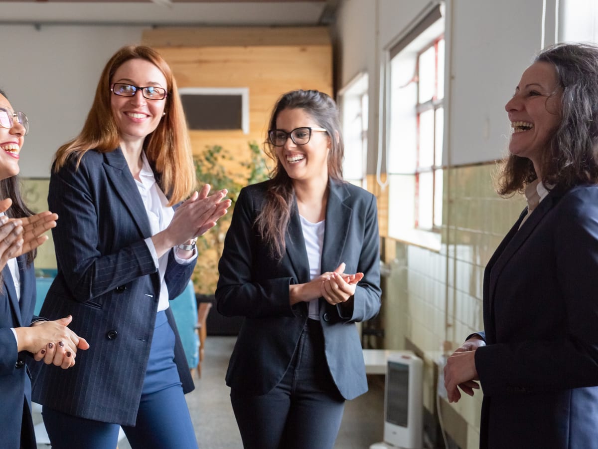 A diverse team of colleagues laughing together in an office